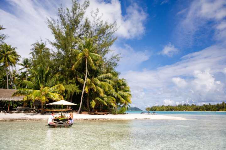 A couple having water lunch on a private island in Bora Bora