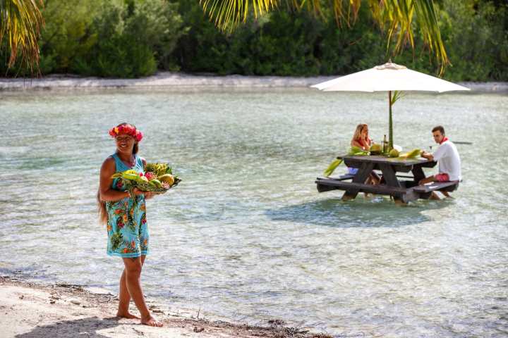 A couple having water lunch on a private island in Bora Bora